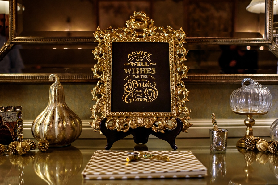 A gold sign in book outside of the ceremony.